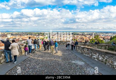 Die Menschen spazieren auf der berühmten Touristenfußgängerstraße (Via Sant'Alessandro) in der Nähe der Porta San Giacomo in der Oberstadt von Bergamo, Italien Stockfoto