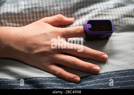 Nahaufnahme einer Hand mit einem Pulsoximeter am Finger. Stockfoto