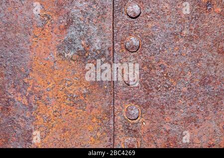 Verrostete, vernietete alte, korrodierte Hintergrundtextur aus Blecheisen Stockfoto