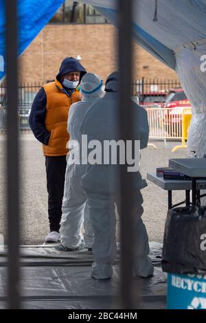 Jersey City, New Jersey, USA. April 2020. Ein Mann wird von einem Arzt in Schutzausrüstung auf dem Covid-19-Testgelände am Marin Boulevard in Jersey City, New Jersey getestet. Pflichtgutschrift: Kostas Lymperopoulos/CSM/Alamy Live News Stockfoto