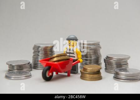 Florianopolis, Brasilien, 28. März 2020: Miniaturen von Bankräubern, die Geld stehlen. Diebe, die Münzen auf weißem Hintergrund tragen. Selektiver Fokus. LEGO m Stockfoto
