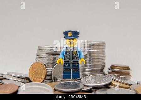 Florianopolis, Brasilien, 28. März 2020: Minifigure des Polizisten auf einem Geldhaufen. Der wahre Held verdiente größere Anerkennung für seine Tapferkeit. LEGO mi Stockfoto