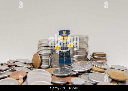 Florianopolis, Brasilien, 28. März 2020: Polizist in Uniform mit Handschellen, die von Korruption in der Nähe von Münzen gefesselt wurden. Polizeibeamte mit Handschellen wegen Vergehen. Lego Stockfoto