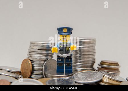 Florianopolis, Brasilien, 28. März 2020: Polizist in Uniform mit Handschellen, die von Korruption in der Nähe von Münzen gefesselt wurden. Polizeibeamte mit Handschellen wegen Vergehen. Lego Stockfoto