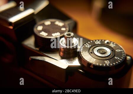 Nahaufnahmen von Details eine russische 35mm-Filmkamera Zenit TTL, die auf einem Holzschreibtisch liegt. Stockfoto