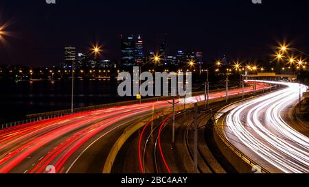 Vehicle Light Trails auf dem Perth Kwinana Freeway mit Perth City im Hintergrund Stockfoto