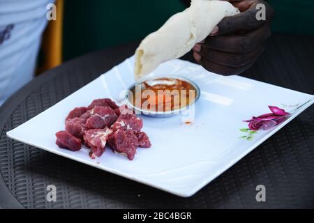 Ein äthiopischer Mann, der Injera Be Reifen siga isst (Injera mit rohem Fleisch) Stockfoto