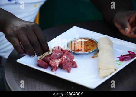 Ein äthiopischer Mann, der Injera Be Reifen siga isst (Injera mit rohem Fleisch) Stockfoto