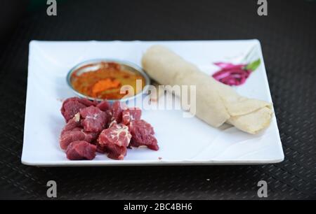 Ein äthiopischer Mann, der Injera Be Reifen siga isst (Injera mit rohem Fleisch) Stockfoto