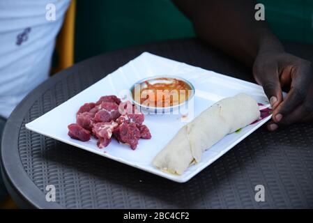 Ein äthiopischer Mann, der Injera Be Reifen siga isst (Injera mit rohem Fleisch) Stockfoto