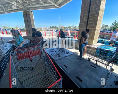 Käufer sind bei Costco dabei, soziale Distanzierung aufrechtzuerhalten. Holzpaletten wurden aufgestellt, um Menschen dabei zu helfen, sich auseinander zu halten und eine Linie zu bilden, die genügend Raum zueinander hat. Stockfoto