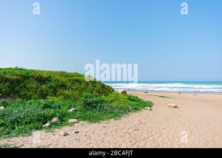 Strand in Casablanca Marokko mit einem grünen Hügel und dem Atlantik Stockfoto