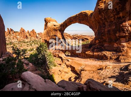 Ein Wanderer, der sich dem Double O Arch im Arches National Park, Utah, USA nähert. Stockfoto