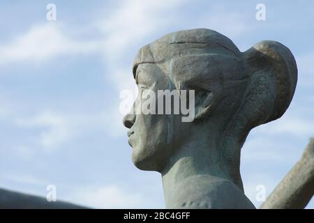 Weibliches Gesicht im Profil, Marmor aus dem Denkmal, Nahaufnahme auf blauem Himmel Stockfoto