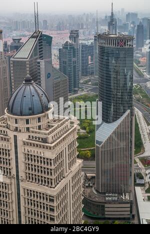 Shanghai, Pudong, Lujiazui, China - 4. Mai 2010: Nahaufnahme von Beige mit Kuppel China Ping ein Finanzgebäude und grüner Glas-Bank-China-Turm auf dem Stockfoto