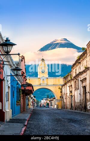 Der berühmte Santa Catalina Arch in Antigua, Guatemala mit dem Vulkan Agua im Hintergrund. Stockfoto