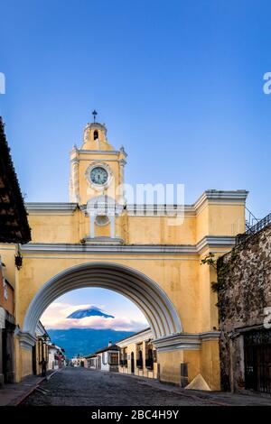 Der berühmte Santa Catalina Arch in Antigua, Guatemala mit dem Vulkan Agua im Hintergrund. Stockfoto