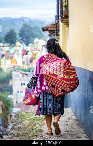 Eine Frau geht nach dem Einkaufen auf dem Markt in Chichicastenango, Guatemala, nach Hause. Stockfoto