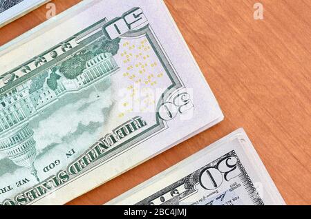 Stapel von vielen einhundertfünfzig Dollar-Scheinen auf Holzhintergrund liegen dicht beieinander. Flacher Lay Draufsicht. Abstrakter Erfolg oder Geschäftskonzept Stockfoto