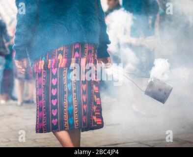 Eine ältere maya-frau schwingt ein Thurible außerhalb der Thomaskirche in Chichicastenango, Guatemala. Stockfoto