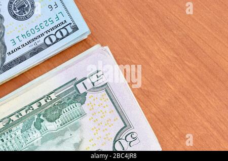 Stapel von vielen einhundertfünfzig Dollar-Scheinen auf Holzhintergrund liegen dicht beieinander. Flacher Lay Draufsicht. Abstrakter Erfolg oder Geschäftskonzept Stockfoto