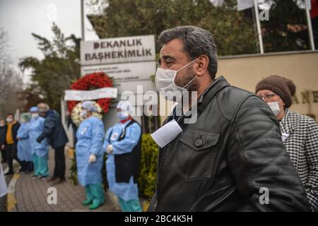 (200403) -- ISTANBUL, 3. April 2020 (Xinhua) -- türkische Gesundheitsarbeiter schließen sich am 2. April 2020 in einem Moment der Stille vor einem Krankenhausgebäude in Istanbul, Türkei, an. Türkische Gesundheitsarbeiter nahmen am Donnerstag an einer Zeremonie zu Ehren eines prominenten türkischen Arztes Teil, der an der COVID-19 in Istanbul starb. Der türkische Gesundheitsminister Fahrettin Koca verkündete am Mittwoch auf einer Pressekonferenz den Tod von Cemil Tascioglu, einem Arzt für Endokrinologie an der Capa-Universität Istanbul. Hunderte von Gesundheitspersonal der Capa Univesity schlossen sich in einem Moment der Stille vor dem Krankenhausgebäude an. (Xinhu Stockfoto