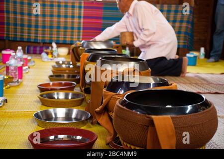 YASOTHON, THAILAND - 12. JANUAR: Thailändische Leute geben in Retro h Speiseangebote der Tradition des Almsgiving mit klebrigem Reis und Essen in die buddhistische Almosenschale Stockfoto