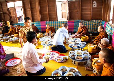 YASOTHON, THAILAND - 12. JANUAR: Thailändische Leute geben in Retro Speisen der Tradition des Almsgiving mit klebrigem Reis und Essen in die buddhistische Almosenschale Stockfoto