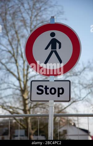 Ein rundes Straßenschild in weiß und rot mit einem schwarzen Mann in der Mitte und einem zusätzlichen Schild: Keine Fußgänger dürfen weiterfahren, Halt Stockfoto