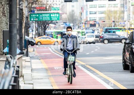 Mann, der mit dem Fahrrad unterwegs ist und während der Coronavirus Pandemie, Seoul, Südkorea, eine Maske trägt Stockfoto