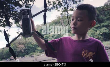 HO-CHI-MINH-STADT/VIETNAM, JUNI 2019 - Mavic Pro Platinum Drone on Kid's Hand im Freien Stockfoto