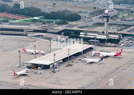 Abgesetzte Stand geparkte Flugzeuge von LATAM (alte TAM). Luftaufnahme der Passagiere Terminal in Sao Paulo Guarulhos International Airport in Brasilien. ATC Tower. Stockfoto