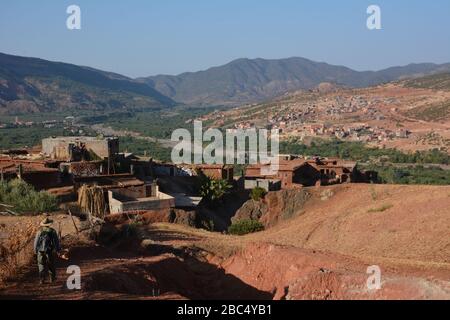 Ein Reiseleiter führt Sie durch ein Dorf im Amazigh-Berber-Gebirge in der Nähe von Asni im marokkanischen Atlasgebirge. Stockfoto