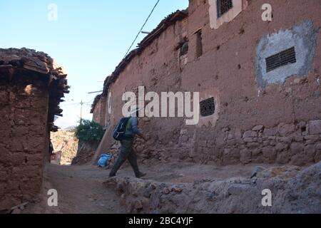 Ein Reiseleiter führt Sie durch ein Dorf im Amazigh-Berber-Gebirge in der Nähe von Asni im marokkanischen Atlasgebirge. Stockfoto