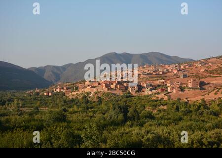 Ein fruchtbares Tal mit traditionellen Bewässerungstechniken und Quellwasser bewässert & ein Amazigh Berber Dorf in der Nähe von Asni in Marokkos Atlasgebirge. Stockfoto