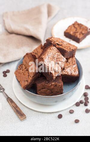 Frisch gebackene hausgemachte Schokoladenkuchen in grauer Schüssel. Grauer Hintergrund. Stockfoto