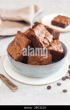 Frisch gebackene hausgemachte Schokoladenkuchen in grauer Schüssel. Grauer Hintergrund. Stockfoto