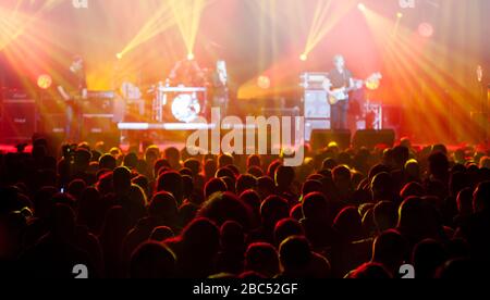 Bühne leuchtet auf Konzert. Beleuchtungseinrichtungen mit mehrfarbigen Balken. Silhouetten von Menschen und Musikern in großer Konzertbühne. Stockfoto