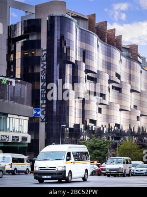 Johannesburg, Südafrika 18. Februar bis 2020: Kleinbustaxen, die an modernen Bürogebäuden vorbeifahren. Stockfoto