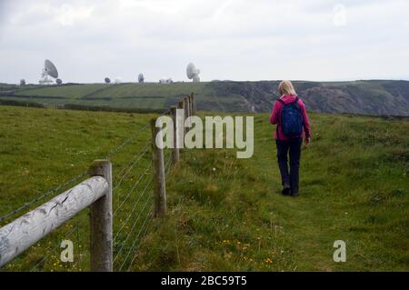 Einreisende Frau auf dem Weg zum GCHQ Bude Radar Hörstation auf dem South West Coastal Path, North Cornwall, England, Großbritannien. Stockfoto