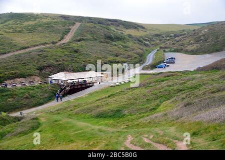 Leute, die am Cafe & Car Park Sandymouth Bay/Cove am South West Coast Path, North Cornwall, spazieren. England, Großbritannien. Stockfoto