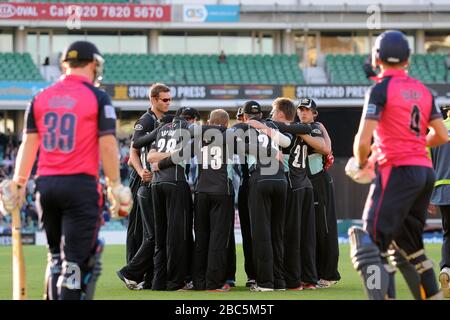 Surrey Lions-Spieler bilden einen Huddle, da Middlesex Panthers die Batsmen Neil Dexter (rechts) und Paul Smith Stirling sich zum Beginn ihres Innings auf den Weg machen Stockfoto