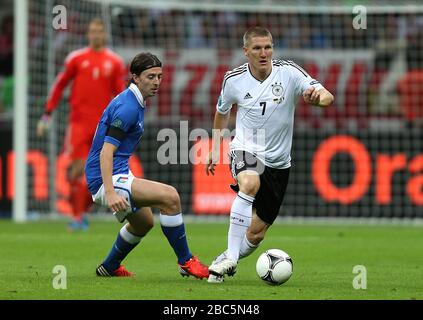 Italiens Riccardo Montolivo (links) und Deutschlands Lukas Podolski im Einsatz Stockfoto