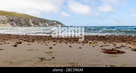 Niedriger Blick vom Alum Bay Strand mit Akroossand und Schindeln zum Leuchtturm Needles Stockfoto