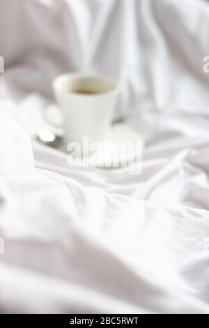 Gemütlicher Blick Auf Das Abstrakte Schlafzimmer Mit Weißem Schlafzimmer. Skandinavisches Interieur. Bleib mit Kaffee im Bett zu Hause. Stockfoto