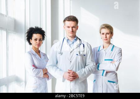 Attraktiver männlicher Arzt vor seinem Ärzteteam Stockfoto