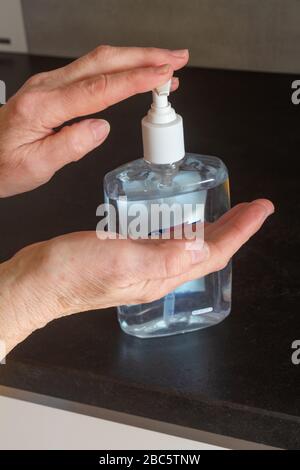 Hydro-alkoholische Gel an die Hände legen, um sie zu desinfizieren Stockfoto