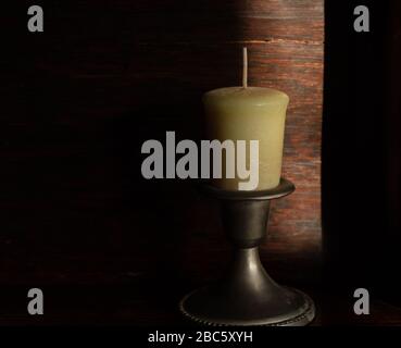 Kerze vor dunklem Hintergrund gesehen. Stockfoto