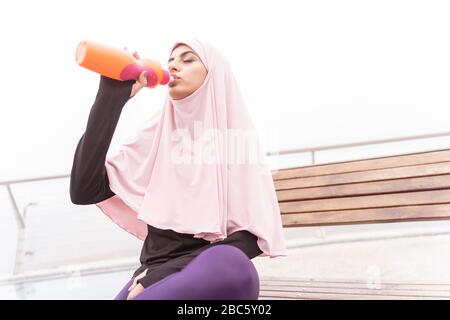 Frau im Hijab Trinkwasser im Freien Foto Stockfoto