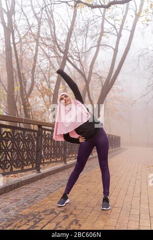 Moslemische Sportlerin trainiert im Park und macht beugt Stock-Foto Stockfoto